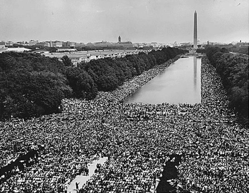 View of the crowd at 1963 Civil Rights March on Washington, D.C. A wide-angle view of marchers along the mall, showing the Reflecting Pool and the Washington Monument.